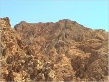 In der Wste wechseln sich Bergmassive in verschiedenen Farben mit weiten, flachen Steinfeldern ab. 
